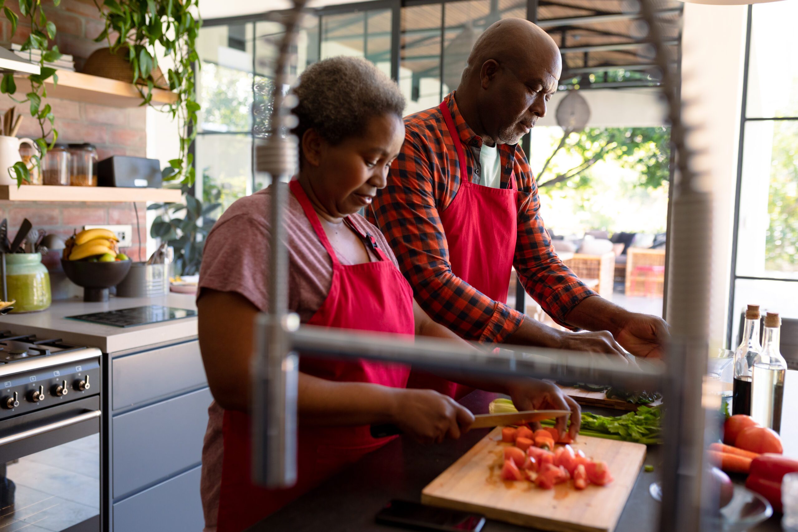 African american senior couple cooking together in kitchen