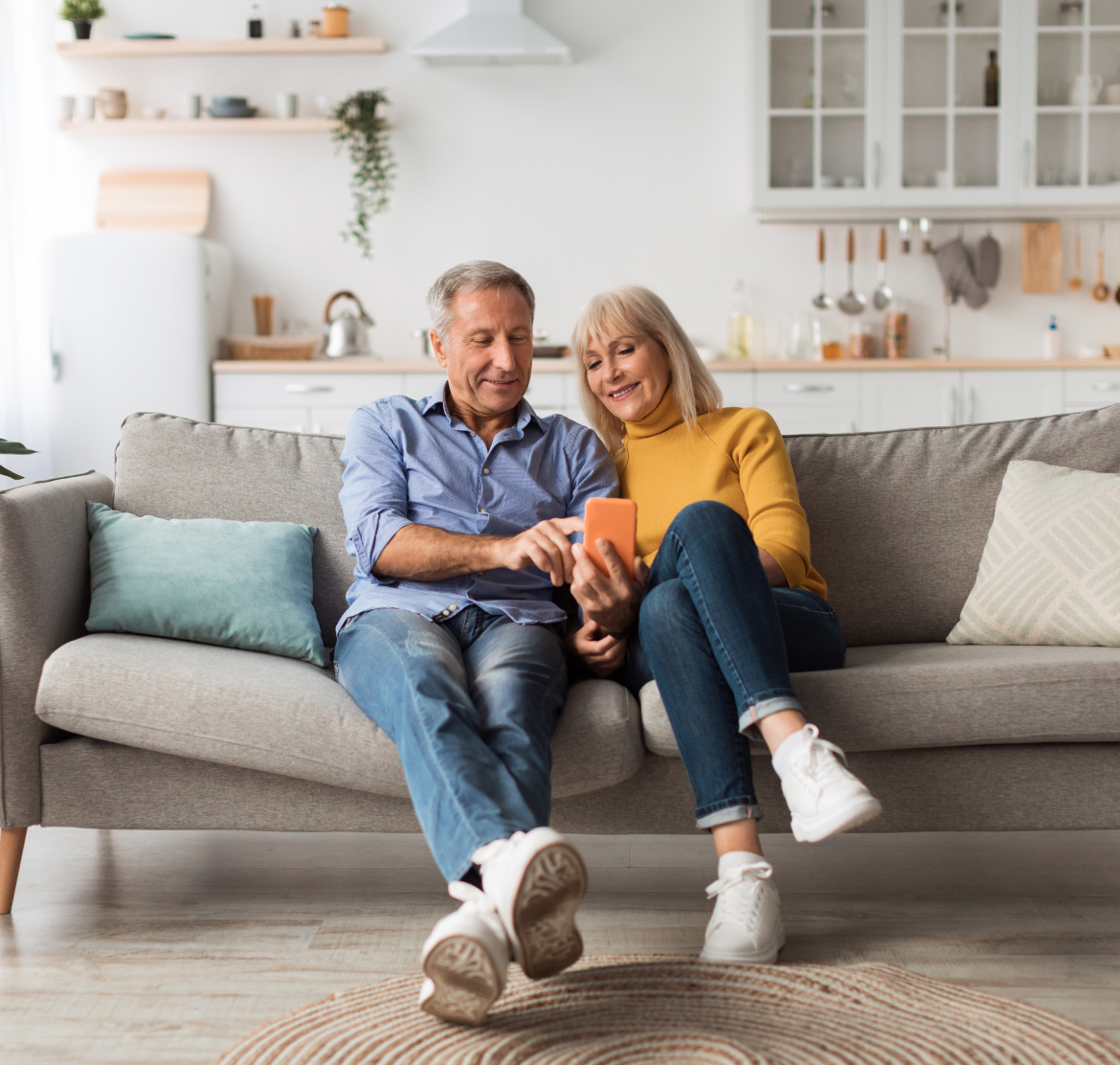 Happy couple on couch looking at the phone