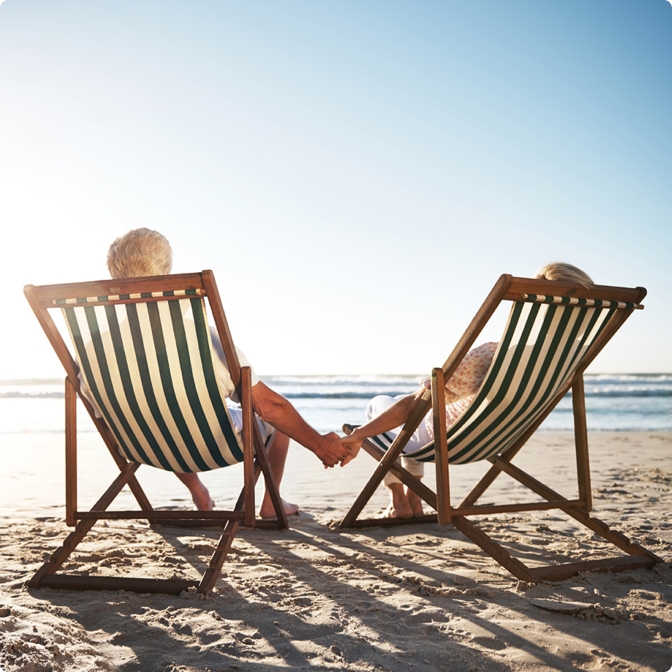 Happy retired couple on the beach We provide high quality retirement income products and annuity life insurance.