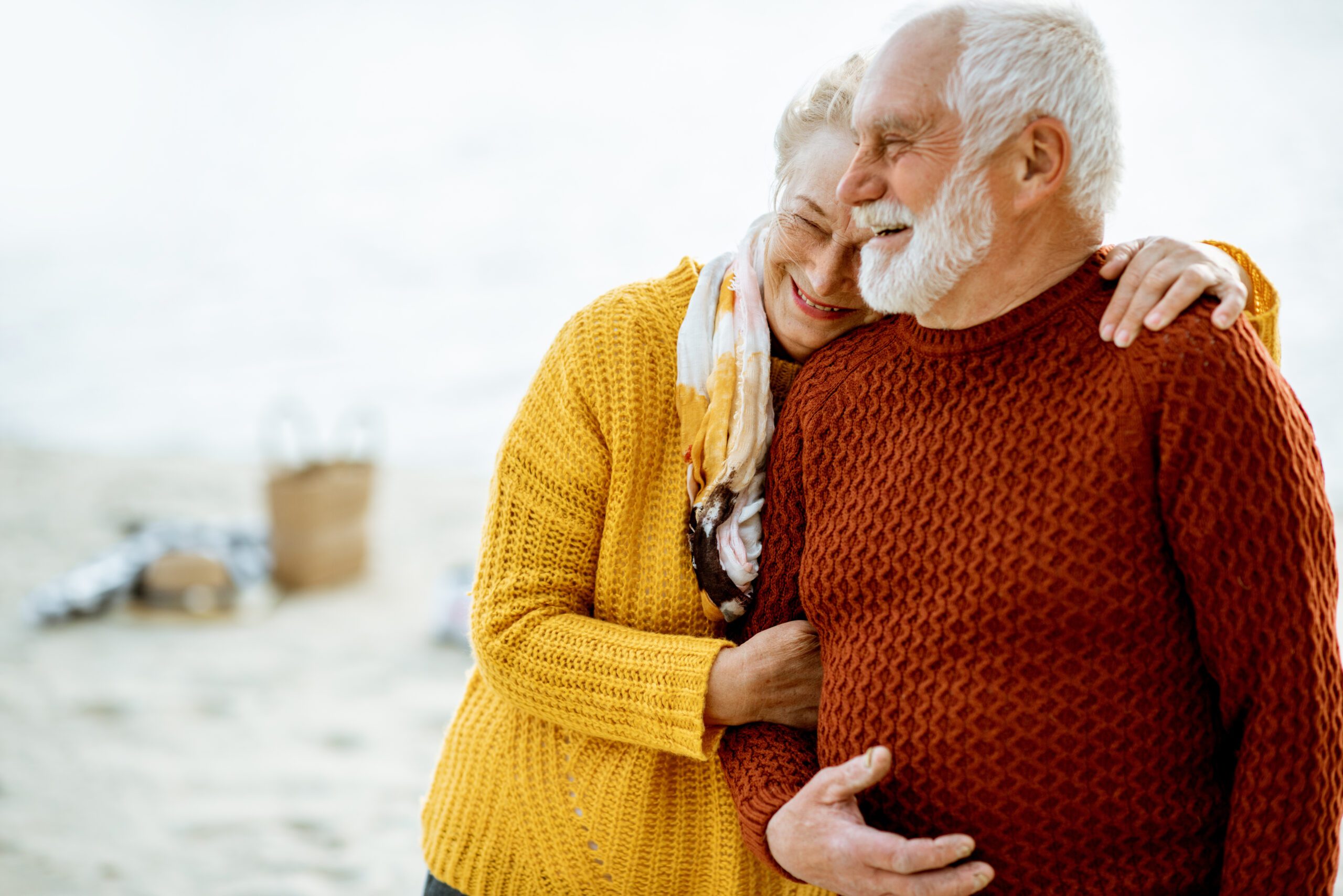 Senior couple in sweaters on the seashore